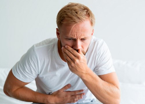 Мужчину тошнит Мужчина держится за живот